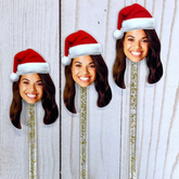 Custom drink stirrers with printed faces on sticks, with options of different hats, in this case, a Santa hat.